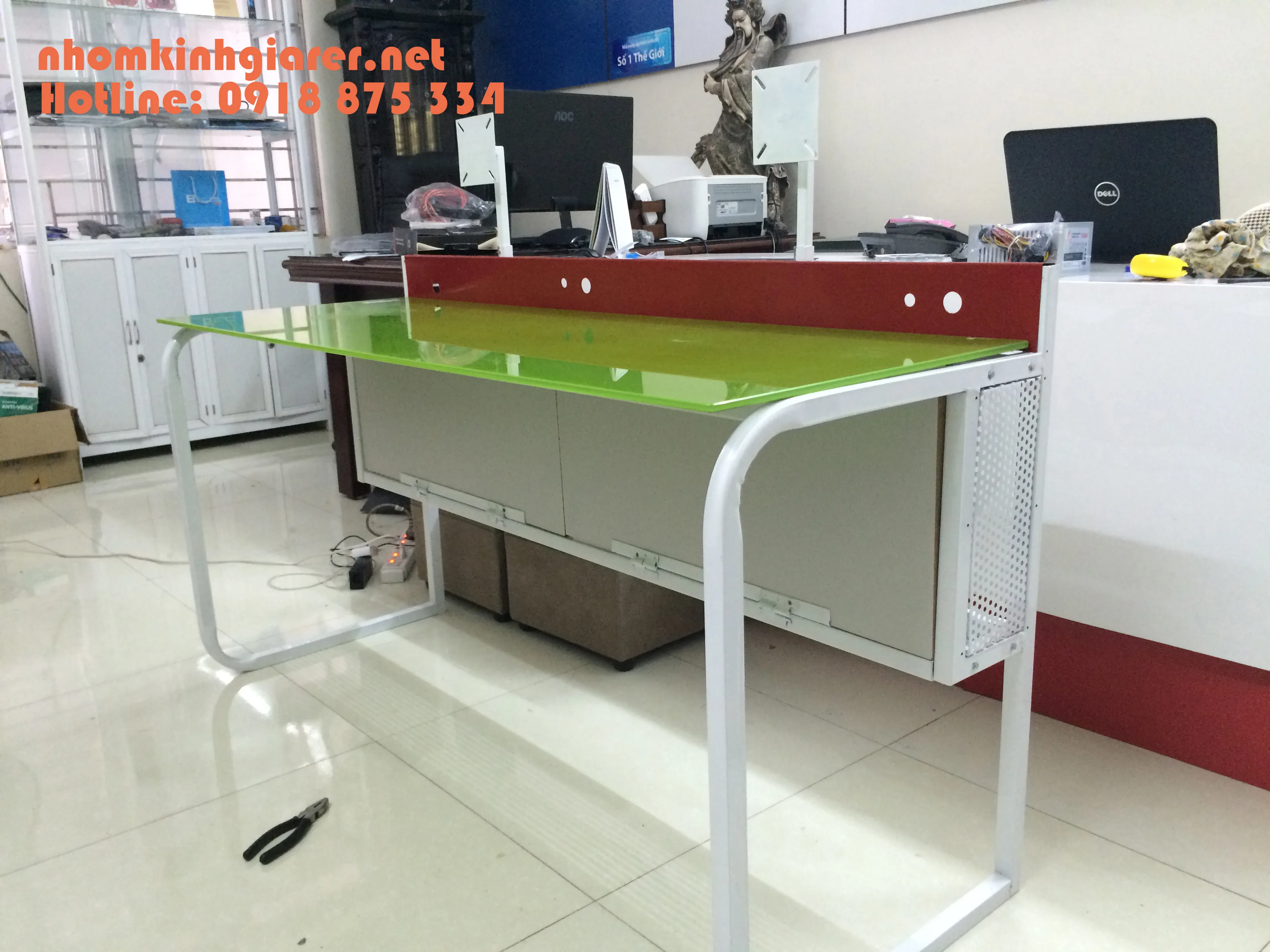 Mặt kính màu xanh đặt trên khung bàn làm việc có vách chia