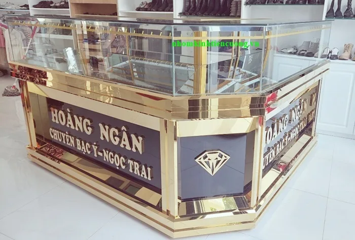 Quầy trưng bày có góc vát, phần kính phía trên và mặt trang trí màu vàng phía dưới